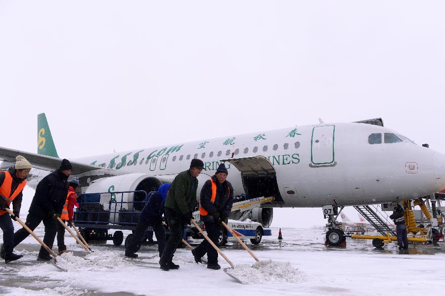 Workers clean snow in Changchun Longjia International Airport in Changchun, capital of northeast China's Jilin Province, Nov. 14, 2012. Most of flights departing from and arriving at the airport were not affected by the heavy snowstorm that precipitated from Sunday until Tuesday. (Xinhua/Lin Hong) 