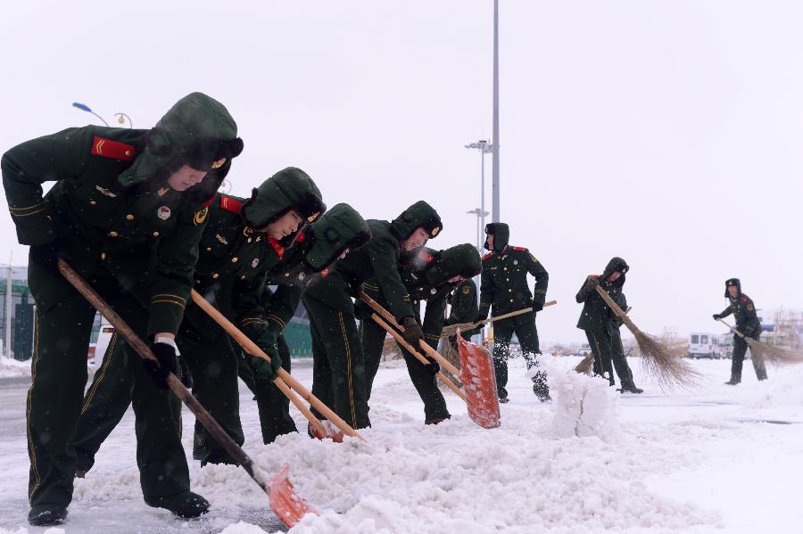 Paramilitary policemen clean snow in Changchun Longjia International Airport in Changchun, capital of northeast China's Jilin Province, Nov. 14, 2012. Most of flights departing from and arriving at the airport were not affected by the heavy snowstorm that precipitated from Sunday until Tuesday. (Xinhua/Lin Hong) 