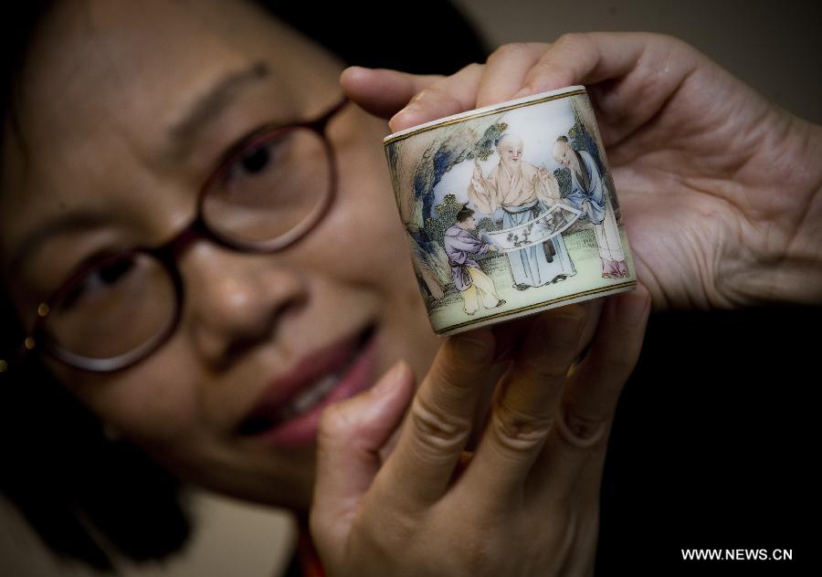 A staff member shows a brush pot of Qing Dynasty (1644-1911), on a press conference of the Christie's autumn auction preview event in south China's Hong Kong, Nov. 14, 2012. The auction will be held in Hong Kong from Nov. 24 to Nov. 28. (Xinhua/Lui Siu Wai) 