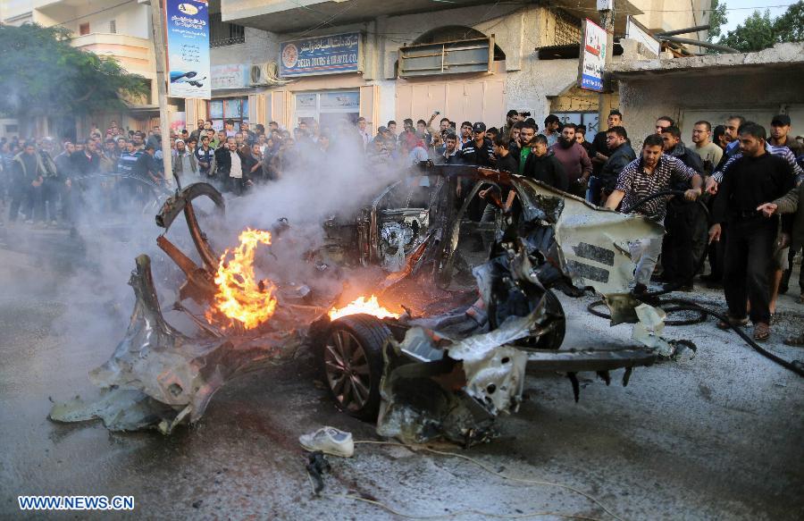 Emergency services extinguish the burned out car of Qassam top leader Ahmed Jabari after an Israeli air strike in Gaza City, Nov. 14, 2012. Hamas says the head of its military wing Ahmed al-Jaabari has been killed in an Israeli air strike. Israel said it had targeted Ahmed al-Jaabari because of what it called his terrorist activity. Seven Palestinians were killed following a series of Israel's airstrikes on Gaza city, and more than 40 others wounded, government's emergency services in the Gaza Strip said. (Xinhua/Wissam Nassar)