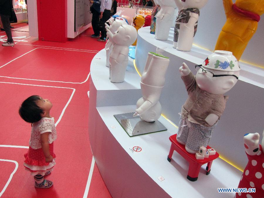 A girl is attracted by sculpture works during a creative sculpture exhibition held in Hong Kong, south China, Nov. 14, 2012. The theme of the exhibition was initiated by conceptual comics of Hong Kong artist Danny Yung. (Xinhua/Zhao Yusi)