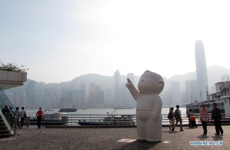 People walk by a creative sculpture in Hong Kong, south China, Nov. 14, 2012. The theme of the exhibition was initiated by conceptual comics of Hong Kong artist Danny Yung. (Xinhua/Zhao Yusi)