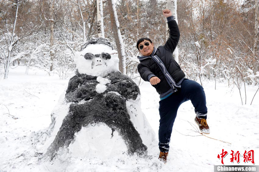 People dance ‘Gangnam style’ in front of a snowman that looks like “Psy” in Changchun on Nov.14 2012. The snow brought a lot of fun for residents in Changchun. (Chinanews/Zhangyao)