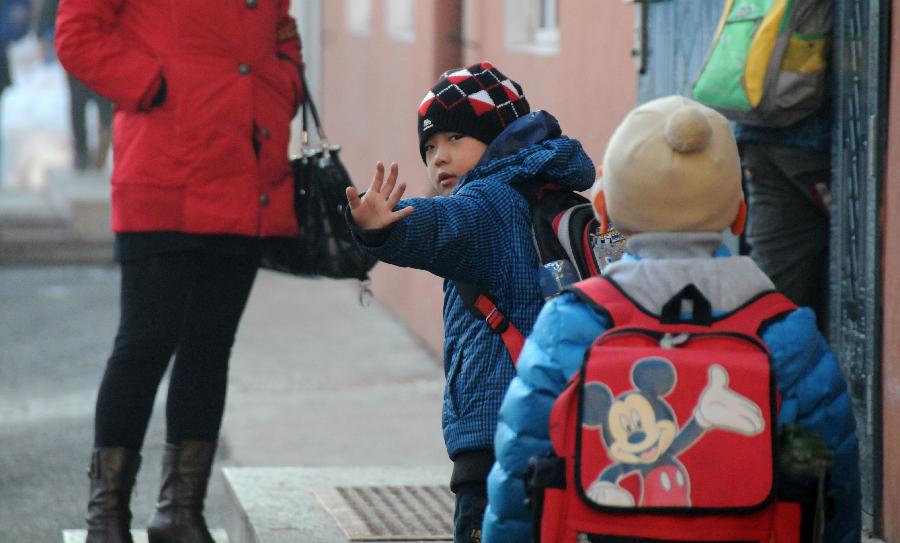 A boy waves goodbye to his parent as he steps into the school in Hegang, northeast China's Heilongjiang Province, Nov. 15, 2012. Students in primary and middle schools in Hegang were back to class on Thursday after two to three days' break which resulted from the heavy snowstorm that hit the city since last Sunday. (Xinhua/Wang Kai) 