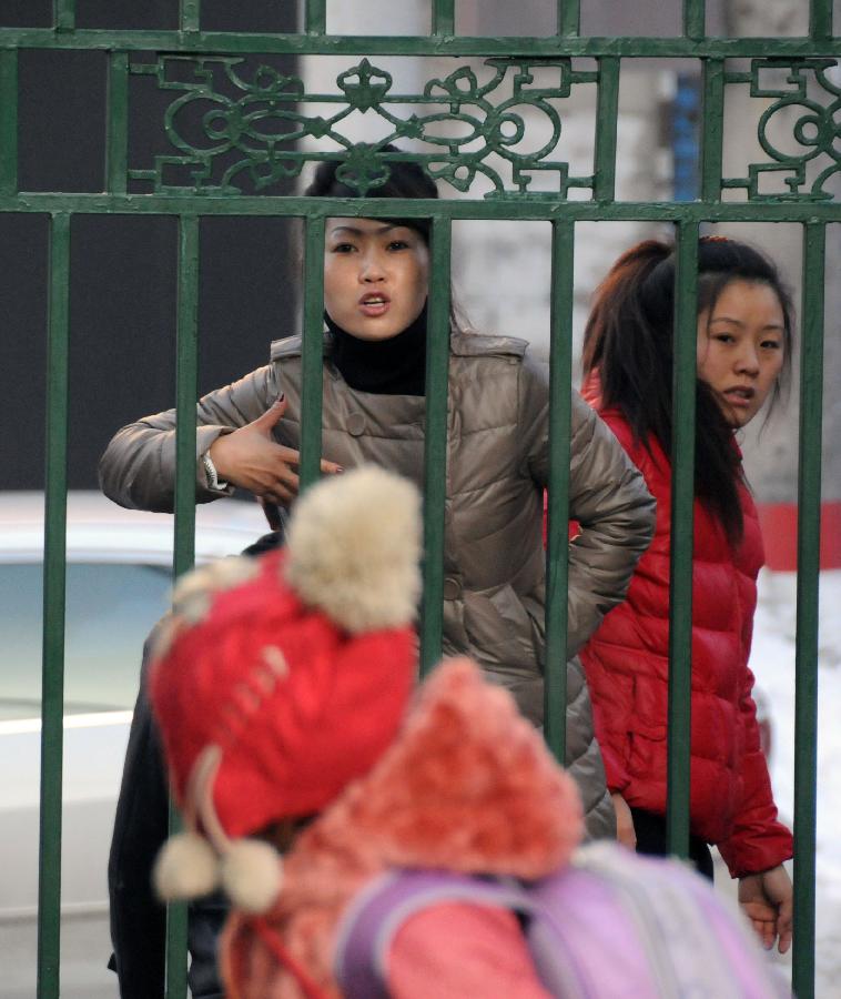 A woman talks to her child against the school gate in a primary school in Hegang, northeast China's Heilongjiang Province, Nov. 15, 2012. Students in primary and middle schools in Hegang were back to class on Thursday after two to three days' break which resulted from the heavy snowstorm that hit the city since last Sunday. (Xinhua/Wang Kai) 