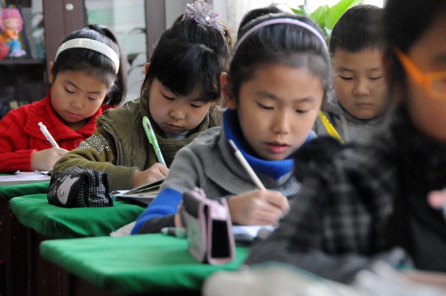 Students have class at a primary school in Hegang, northeast China's Heilongjiang Province, Nov. 15, 2012. Students in primary and middle schools in Hegang were back to class on Thursday after two to three days' break which resulted from the heavy snowstorm that hit the city since last Sunday. (Xinhua/Wang Kai) 