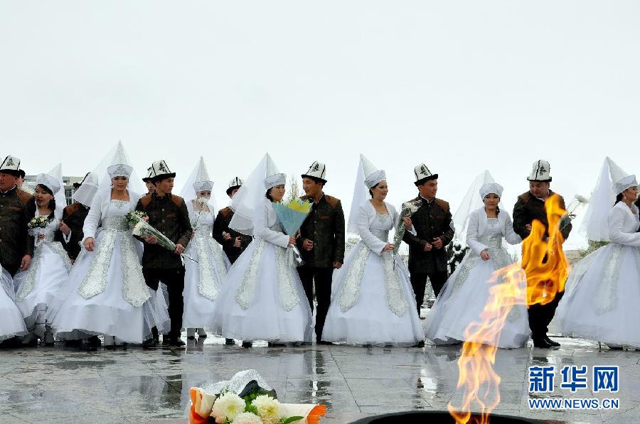 Kyrgyz brides and grooms lay flowers at the Eternal Flame before a mass wedding ceremony in Bishkek, Kyrgyzstan on May 13, 2011. (Xinhua/Luo Man)