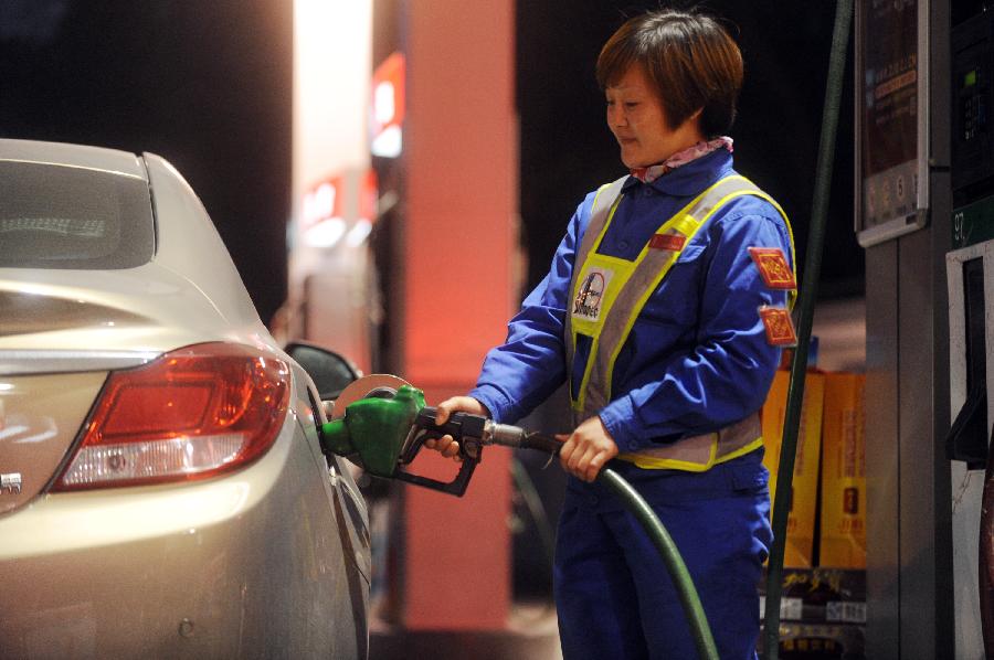 A worker fills a car at a gas station in Hangzhou, capital of east China's Zhejiang Province, Nov. 15, 2012. China will cut the retail prices of gasoline by 310 yuan (49.2 U.S. dollars) and diesel by 300 yuan per tonne starting from Friday, the National Development and Reform Commission (NDRC), the country's top economic planner, said Thursday. (Xinhua/Huang Zongzhi)