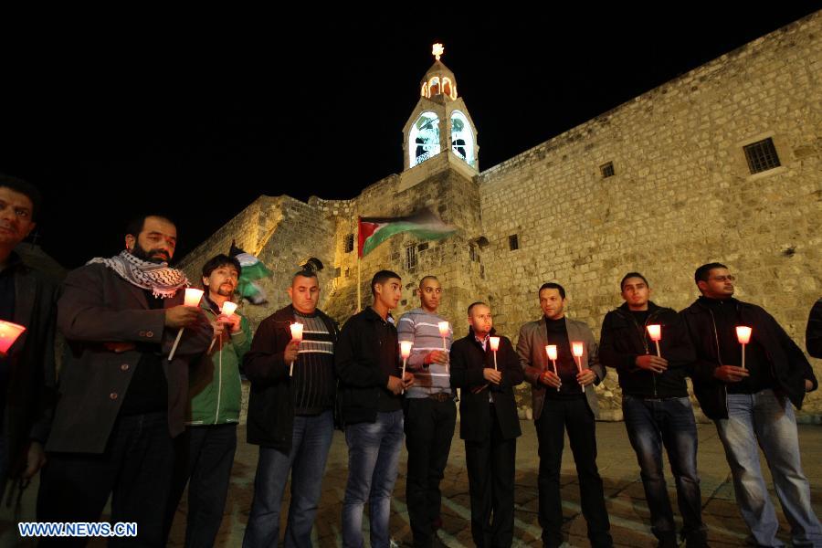Activists hold candles during a solidarity protest near the Church of the Nativity in the West Bank city of Bethlehem on Nov. 14, 2012. Several Palestinians were killed following a series of Israel's concurrent airstrikes on Gaza city, among them was Ahmed al-Jaabari, top commander of Hamas armed wing Al-Qassam brigades, and more than 40 others wounded, government's emergency services in the Gaza Strip said. (Xinhua/Luay Sababa)