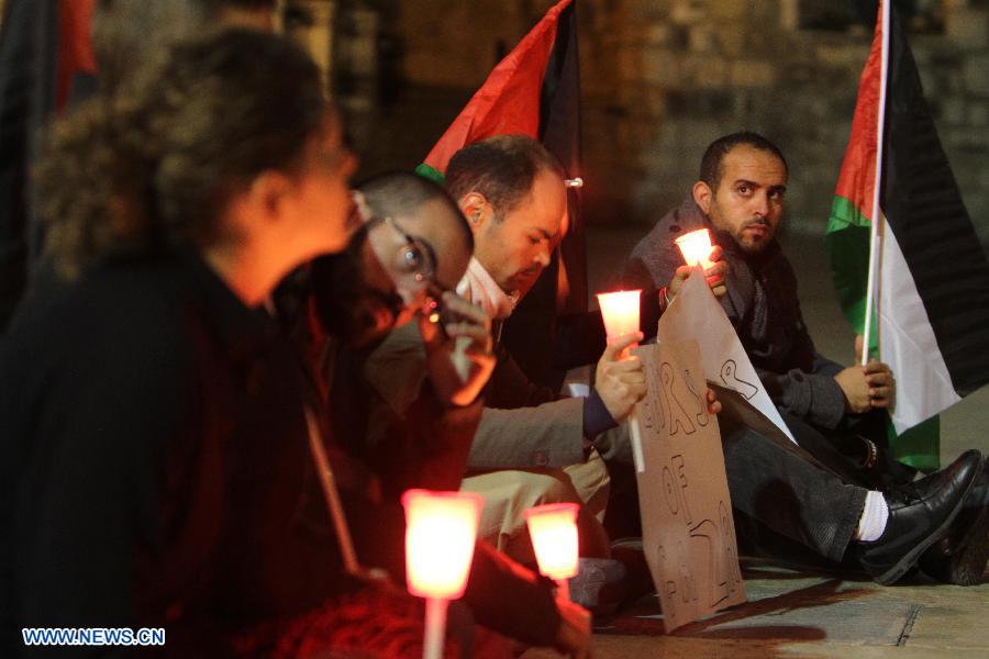 Activists hold candles during a solidarity protest near the Church of the Nativity in the West Bank city of Bethlehem on Nov. 14, 2012. Several Palestinians were killed following a series of Israel's concurrent airstrikes on Gaza city, among them was Ahmed al-Jaabari, top commander of Hamas armed wing Al-Qassam brigades, and more than 40 others wounded, government's emergency services in the Gaza Strip said. (Xinhua/Luay Sababa)