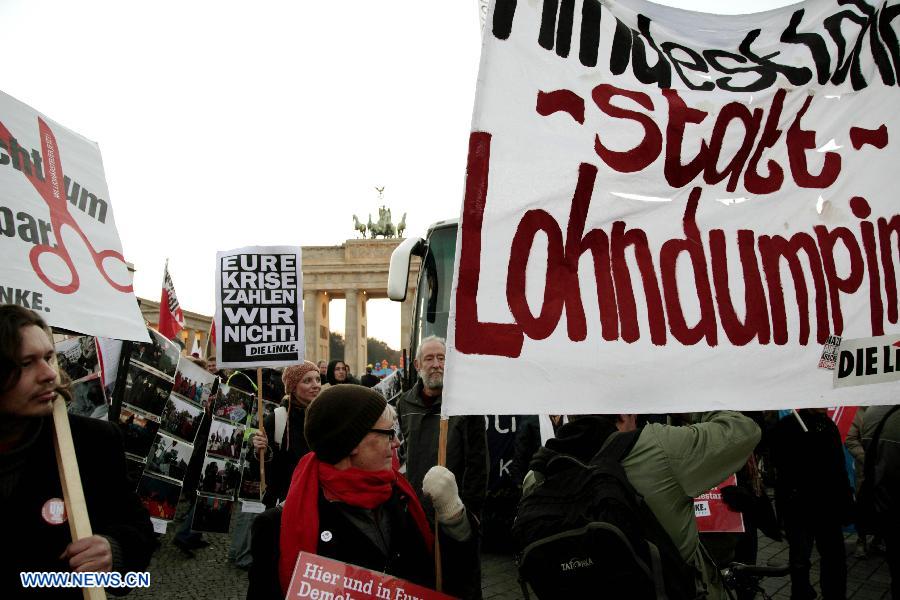 Protesters hold banners during an anti-austerity protest in front of the Brandenburg Gate in Berlin, Germany, Nov. 14, 2012. (Xinhua/Pan Xu) 