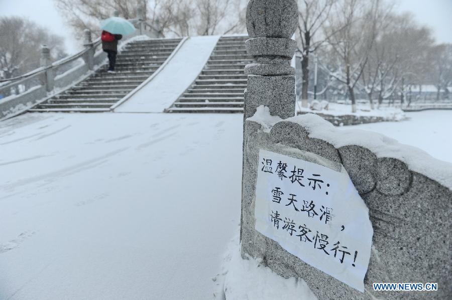 Photo taken on Nov. 16, 2012 shows a sign warning of slippery snow in a park in Changchun, capital of northeast China's Jilin Province. A snowfall hit central and eastern Jilin on Friday. (Xinhua/Zhang Nan) 