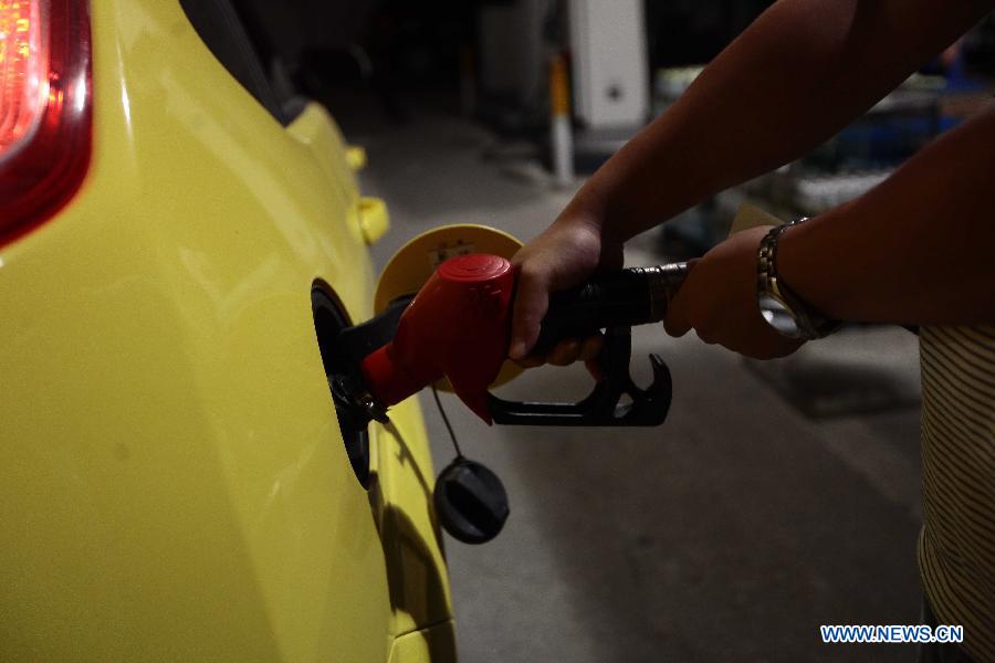 A citizen fuels his car at a self-serve gas station in Sanya City, south China's Hainan Province, Nov. 16, 2012. China cut the retail prices of gasoline by 310 yuan (49.2 U.S. dollars) and diesel by 300 yuan per tonne starting from Friday. The move, following two consecutive rises, was the fourth such cut this year. It was made in response to recent crude price fluctuations on the global market, according to the National Development and Reform Commission (NDRC), the country's top economic planner. (Xinhua/Chen Wenwu)