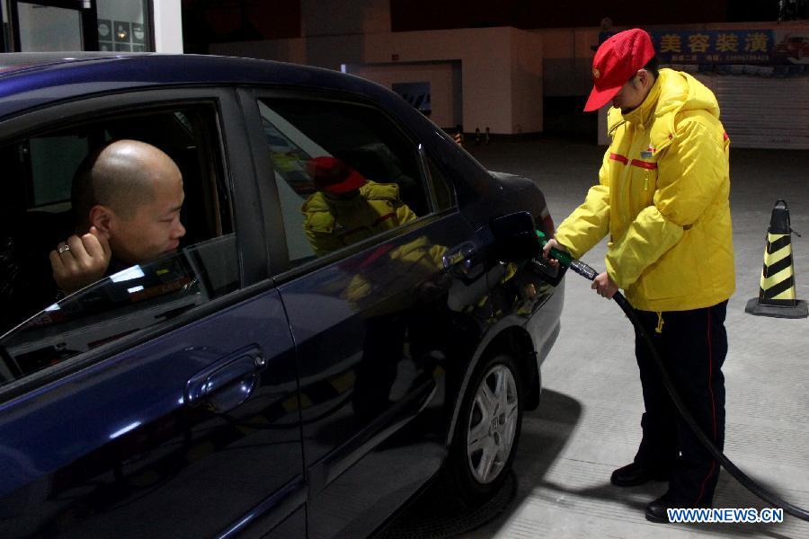 A staff member of a gas station refuels a car in Hefei, capital of east China's Anhui Province, Nov. 16, 2012. China will cut the retail prices of gasoline by 310 yuan (49.2 U.S. dollars) and diesel by 300 yuan per tonne starting from Nov. 16, the National Development and Reform Commission (NDRC), the country's top economic planner, said on Nov, 15, 2012. (Xinhua/Zhang Duan)