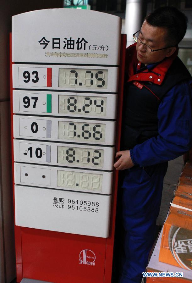 A staff member of a gas station looks at a fuel price board in Shanghai, east China, Nov. 16, 2012. China will cut the retail prices of gasoline by 310 yuan (49.2 U.S. dollars) and diesel by 300 yuan per tonne starting from Nov. 16, the National Development and Reform Commission (NDRC), the country's top economic planner, said on Nov, 15, 2012. (Xinhua/Ding Ting)  