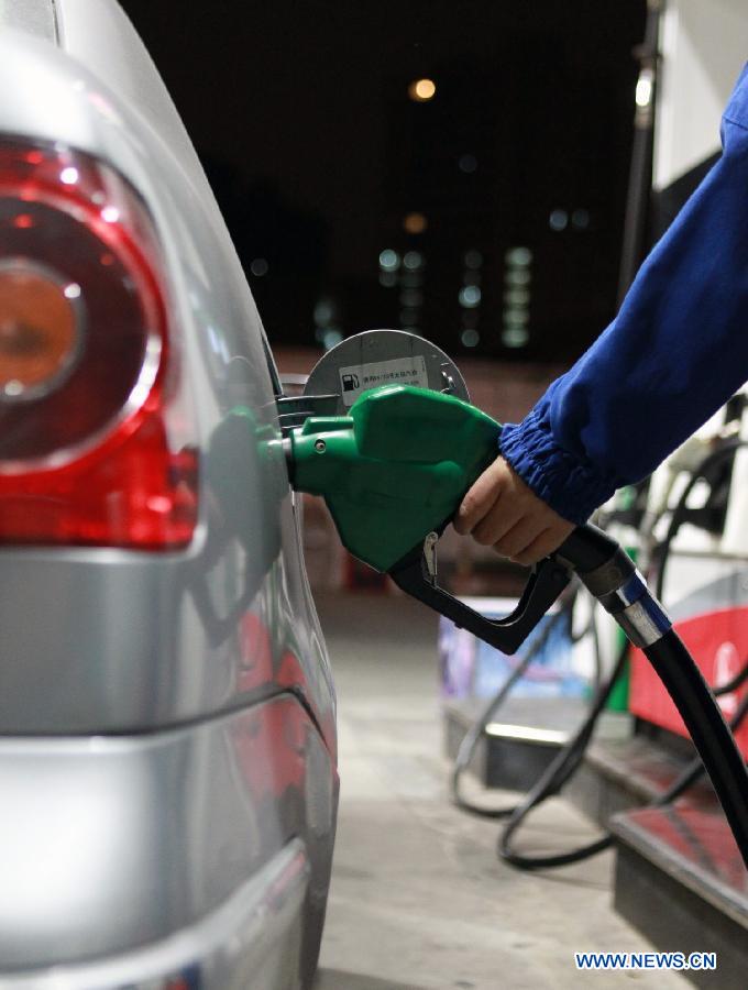 A staff member of a gas station refuels a car in Shanghai, east China, Nov. 16, 2012. China will cut the retail prices of gasoline by 310 yuan (49.2 U.S. dollars) and diesel by 300 yuan per tonne starting from Nov. 16, the National Development and Reform Commission (NDRC), the country's top economic planner, said on Nov, 15, 2012. (Xinhua/Ding Ting) 