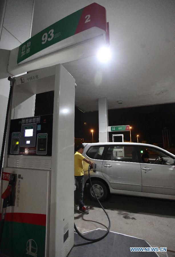 A citizen fuels his car at a self-serve gas station in Sanya City, south China's Hainan Province, Nov. 16, 2012. China cut the retail prices of gasoline by 310 yuan (49.2 U.S. dollars) and diesel by 300 yuan per tonne starting from Friday. The move, following two consecutive rises, was the fourth such cut this year. It was made in response to recent crude price fluctuations on the global market, according to the National Development and Reform Commission (NDRC), the country's top economic planner. (Xinhua/Chen Wenwu)