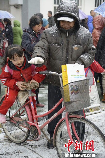 Pictures shows parents picking up children after school in snow in Hohhot on Nov. 15, 2012.(Chinanews/Liu Wenhua)