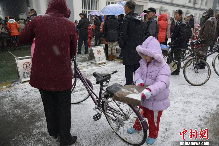 Pictures shows parents picking up children after school in snow in Hohhot on Nov. 15, 2012.(Chinanews/Liu Wenhua)