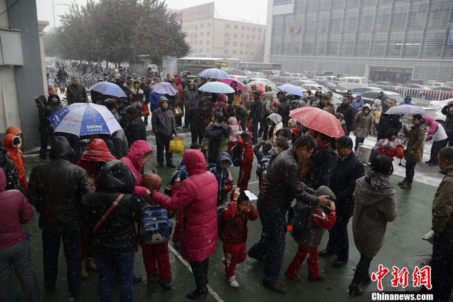 Pictures shows parents picking up children after school in snow in Hohhot on Nov. 15, 2012.(Chinanews/Liu Wenhua)