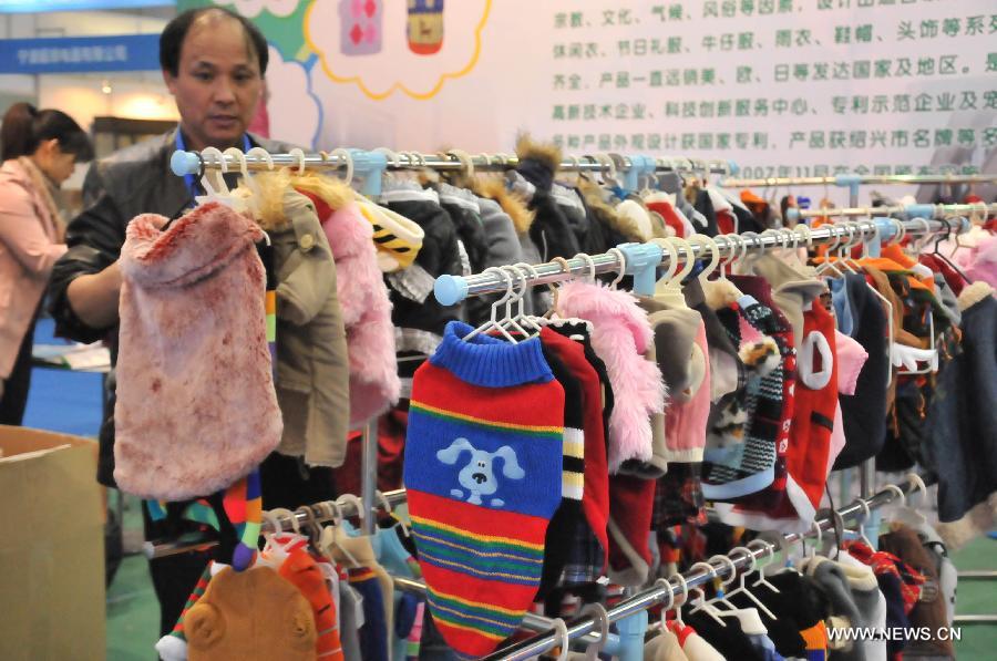 An exhibitor sells pet clothes at the 2012 China(Hangzhou) Pets Cultural Festival in Hangzhou, capital of east China's Zhejiang Province, Nov. 16, 2012. The three-day festival opened here on Friday. (Xinhua/Zhu Yinwei) 