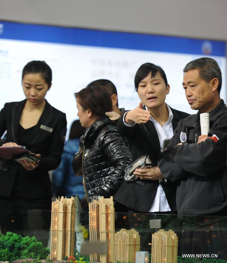 Saleswomen introduce a project to residents at a real estate trade fair in Guiyang, capital of southwest China's Guizhou Province, Nov. 17, 2012. (Xinhua/Tao Liang) 