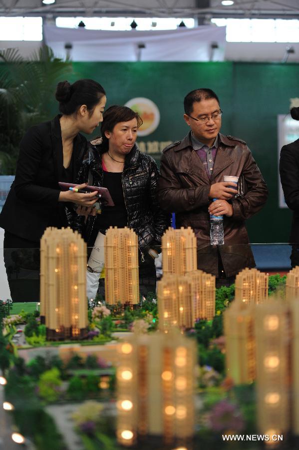 A saleswoman introduces a project to residents at a real estate trade fair in Guiyang, capital of southwest China's Guizhou Province, Nov. 17, 2012. (Xinhua/Tao Liang)