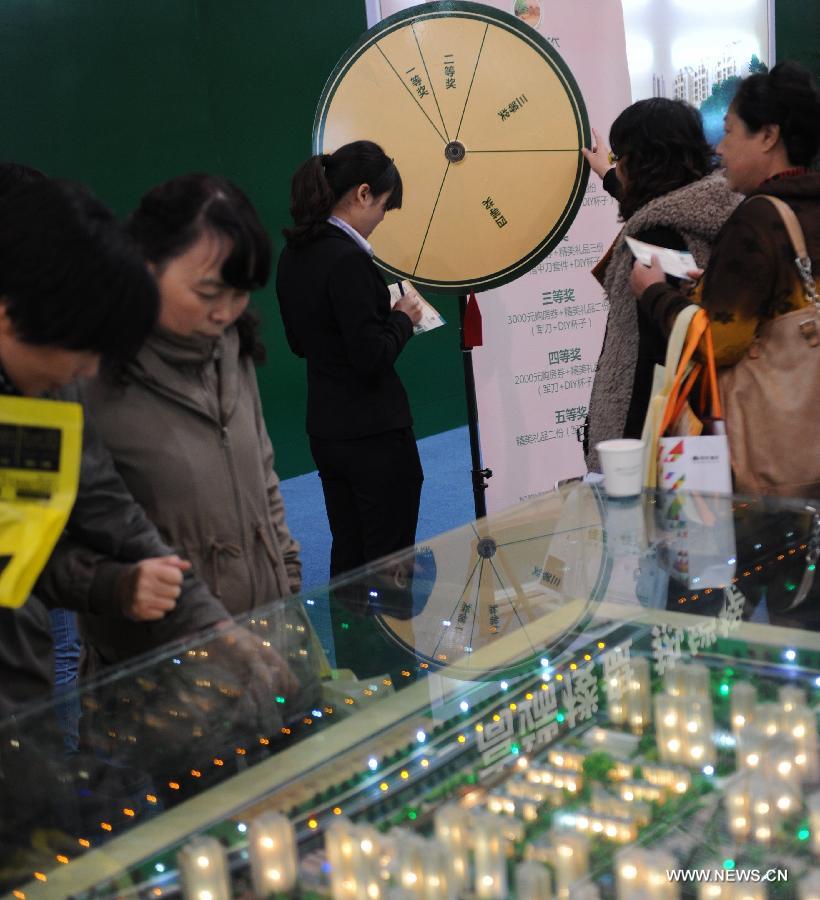 Residents look at building models at a real estate trade fair in Guiyang, capital of southwest China's Guizhou Province, Nov. 17, 2012. (Xinhua/Tao Liang)