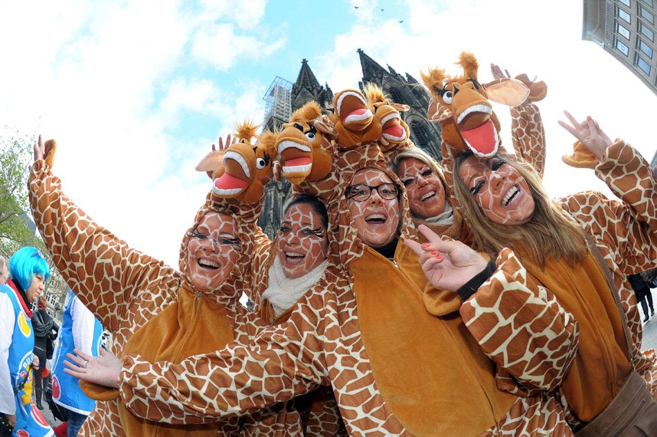 Several women take part in the celebration of Cologne Carnival in giraffe costume in front of the Cologne Cathedral on Nov. 11, 2012. (Xinhua/AFP)