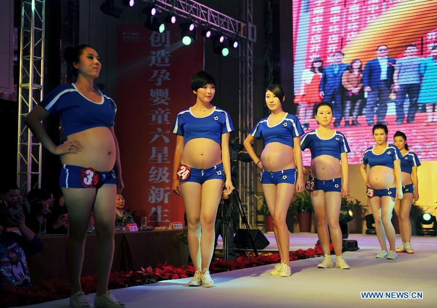 Pregnant women pose at a mothers-to-be pageant in Taiyuan, capital of north China's Shanxi Province, Nov. 18, 2012. A total of 35 expectant mothers attended the pageant which was held on Sunday. (Xinhua/Yan Yan) 