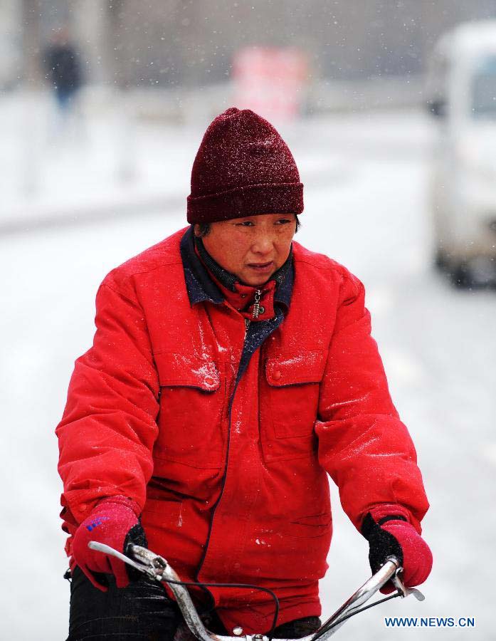 A citizen rides in snow in Harbin, capital of northeast China's Heilongjiang Province, Nov. 17, 2012. Another cold front moving eastward will bring more snow to northeast China in the next three days, along with temperature drops and strong winds in some areas, the National Meteorological Center (NMC) forecast on Saturday. (Xinhua/Wang Jianwei) 