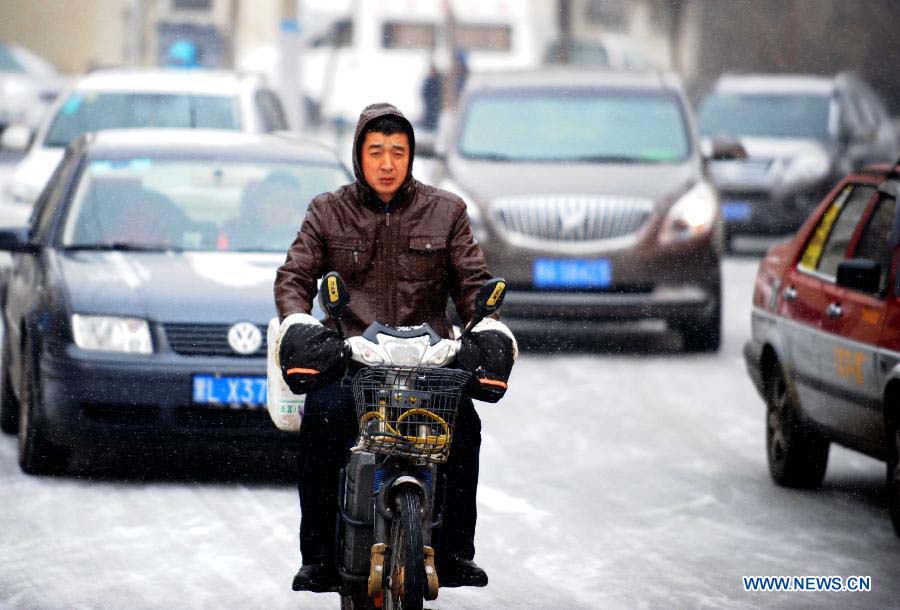 A citizen rides in snow in Harbin, capital of northeast China's Heilongjiang Province, Nov. 17, 2012. Another cold front moving eastward will bring more snow to northeast China in the next three days, along with temperature drops and strong winds in some areas, the National Meteorological Center (NMC) forecast on Saturday. (Xinhua/Wang Jianwei) 