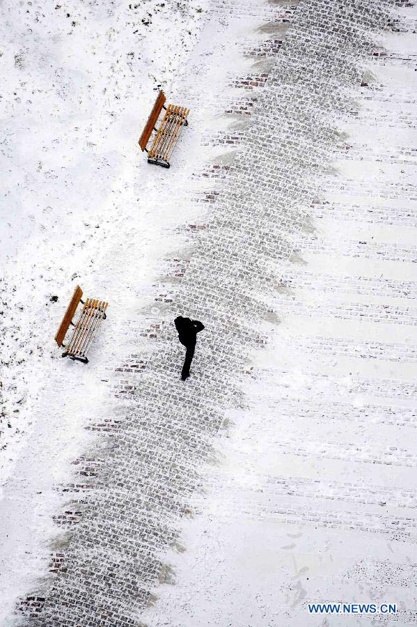 A citizen walks in snow in Harbin, capital of northeast China's Heilongjiang Province, Nov. 17, 2012. Another cold front moving eastward will bring more snow to northeast China in the next three days, along with temperature drops and strong winds in some areas, the National Meteorological Center (NMC) forecast on Saturday. (Xinhua/Wang Jianwei) 