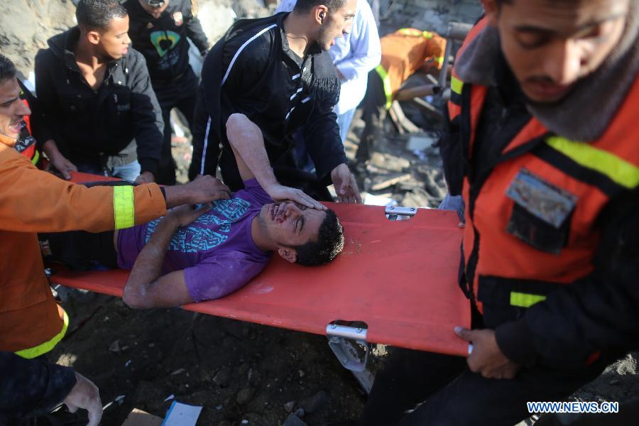 Palestinian civil defense staff members carry a survivor on a stretcher after he was pulled out from the rubble of a destroyed house after an Israeli airstrike on Gaza City, on Nov. 18, 2012. (Xinhua/Wissam Nassar)