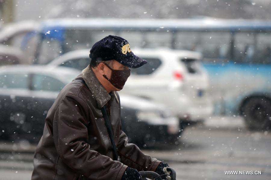 A man rides in snow in Changchun, capital of northeast China's Jilin Province, Nov. 19, 2012. The local meteorological observatory issued a blue warning for further snowstorms on Monday. (Xinhua/Lin Hong) 