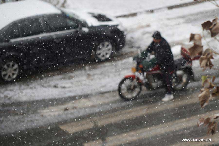 A man rides in snow in Changchun, capital of northeast China's Jilin Province, Nov. 19, 2012. The local meteorological observatory issued a blue warning for further snowstorms on Monday. (Xinhua/Lin Hong) 