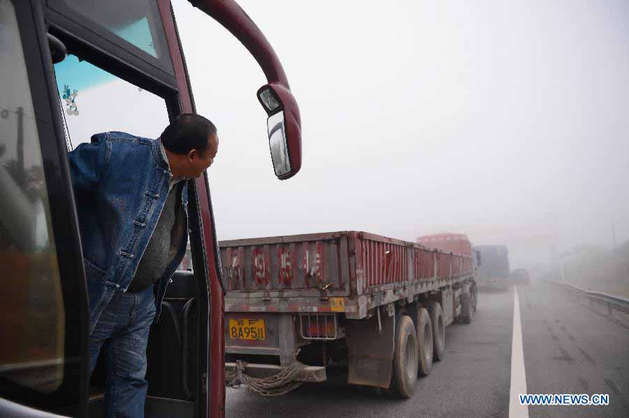 A driver waits in the Changzhang section of the Shanghai-Kunming Highway in Nanchang, east China's Jiangxi Province, Nov. 19, 2012. The highways which closed because of dense fog in the province gradually reopened as the fog disappeared on Monday morning. (Xinhua/Zhou Mi) 