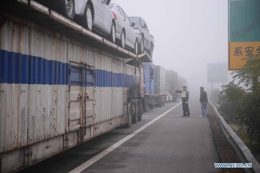 A traffic policeman directs traffic in the Changzhang section of the Shanghai-Kunming Highway in Nanchang, east China's Jiangxi Province, Nov. 19, 2012. The highways which closed because of dense fog in the province gradually reopened as the fog disappeared on Monday morning. (Xinhua/Zhou Mi) 