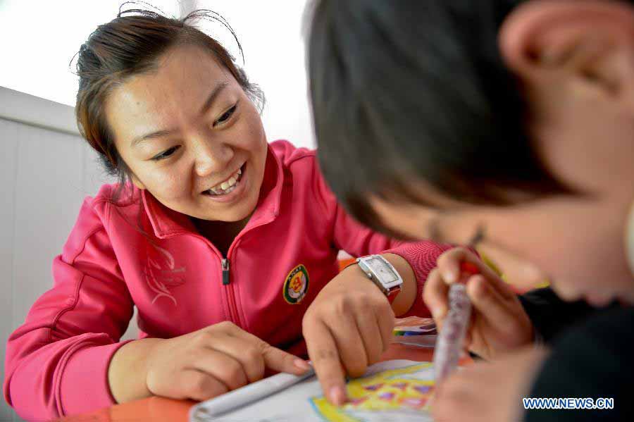 Teacher Zhang Min guides an autistic child in painting in the An'an Autism Rehabilitation Center in Jinan, capital of east China's Shandong Province, Nov. 19, 2012. The center has received over 2,000 children with autism for rehabilitation treatment since its foundation in 2006. More than one-third of the children went to normal kindergartens and schools after 10-14 months' training here. (Xinhua/Guo Xulei) 
