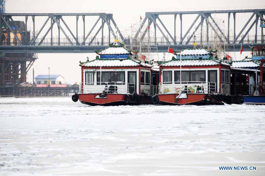 Sightseeing boats are seen on the frozen Songhua River in Harbin, capital of northeast China's Heilongjiang Province, Nov. 19, 2012. Navigation on the Harbin section of Songhua River has been closed since Monday, as the river entered frozen-up season due to the temperature plunge recently. (Xinhua/Wang Kai) 