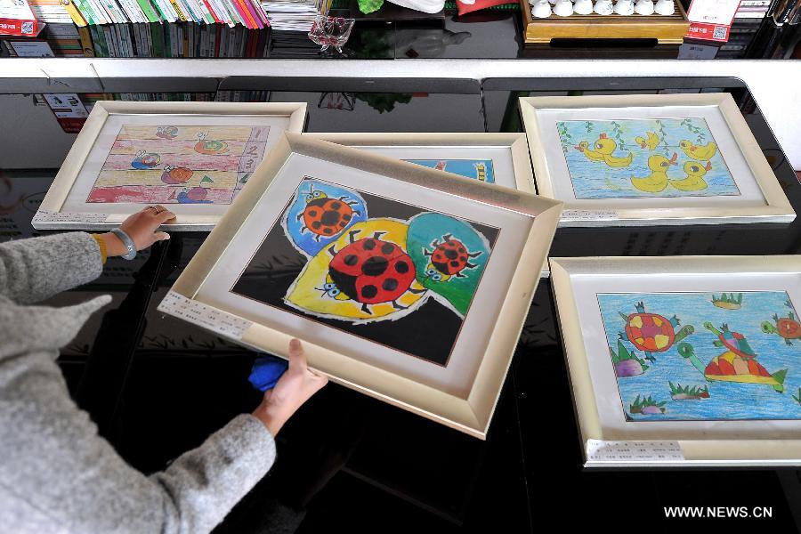 Paintings created by autistic children are seen in Huijia Chuangyi Restaurant in Xiaodian District of Taiyuan City, capital of north China's Shanxi Province, Nov.19, 2012. The restaurant has provided a platform to sell paintings by autistic children from Fangzhou Autism Rehabilitation Center in Shanxi since October in 2011. (Xinhua/Zhan Yan) 