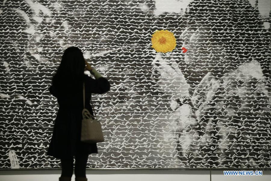 A visitor takes a picture of an art work displayed at the art exhibition "I Love Aijing" in the National Museum of China in Beijing, China, Nov. 19, 2012. The art exhibition, showcasing Ai Jing's creations, kicked off here Monday. Ai Jing, a pop singer who won her fame in 1990s, has been involved in artwork exhibition since 2007, showing her work in Beijing, Shanghai and New York. (Xinhua/Ren Zhenglai) 