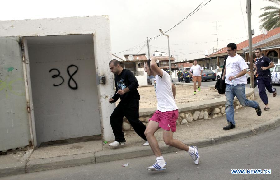 Israelis run to a public bomb shelter in Ofakim, south Israel, as the siren sounds warning of the incoming rocket fired from Gaza on Nov. 19, 2012. (Xinhua/Ariel Jerozolimski) 