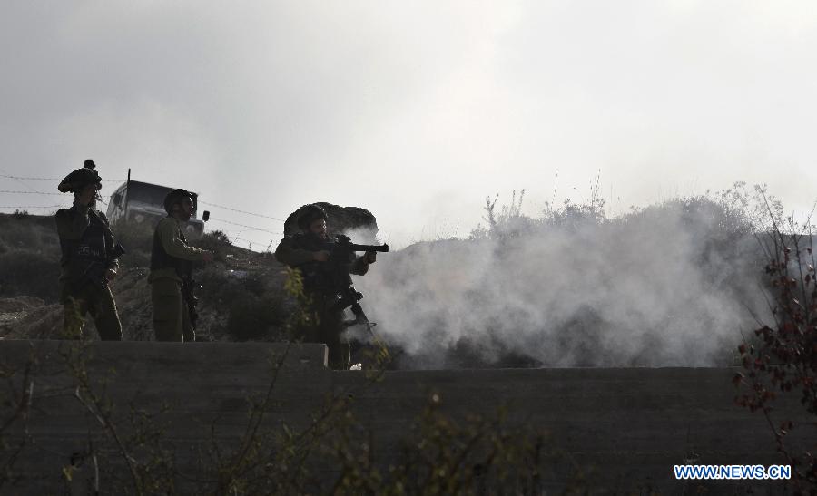 Israeli soldiers fire teargas at Palestinian protesters during clashes after Israeli settlers from Yitzhar settlement have burnt the entrance of a mosque in the West Bank city of Nablus on Nov. 19, 2012. (Xinhua/Ayman Nobani)