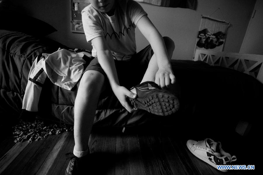 Lisandro Itzcovich, 10 years old, prepares his shoes prior to a training in Buenos Aires, capital of Argentina, on Nov. 19, 2012. (Xinhua/Martin Zabala)