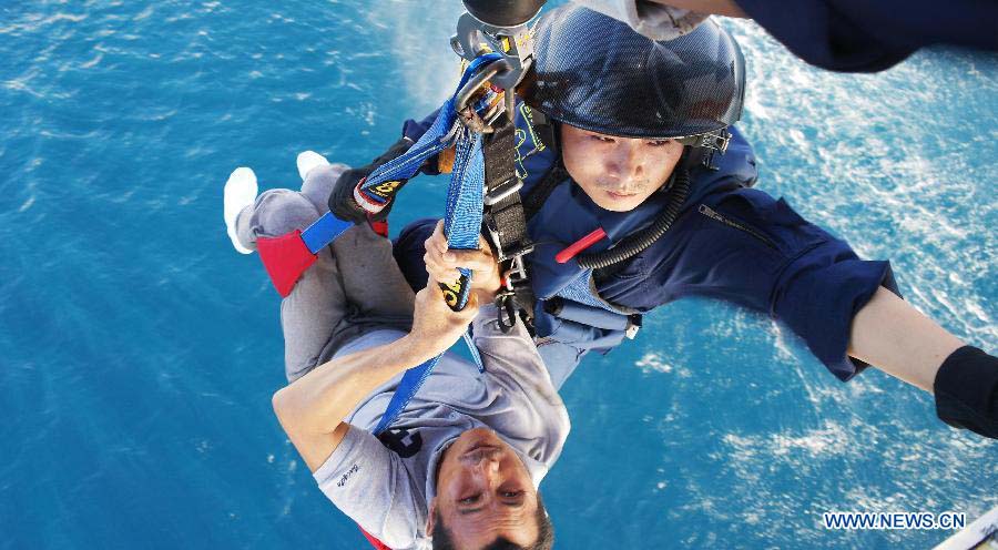 A rescuer of the First Rescue Squadron of the South China Sea carries a sick fisherman to a helicopter at Yongxing Island of Sansha City, south China's Hainan Province, Nov. 18, 2012. The squadron saved two sick fishermen and three missing fishermen from Nov. 17 to Nov. 19. (Xinhua/Chen Jianbo) 