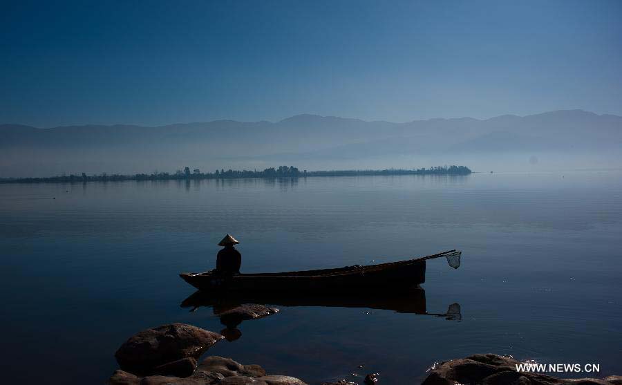 A man fishes in the wetland park at the Qionghai Lake in Xichang City, southwest China's Sichuan Province, Nov. 20, 2012. The Qionghai wetland park attracted many visitors this winter. (Xinhua/Liu Chan)
