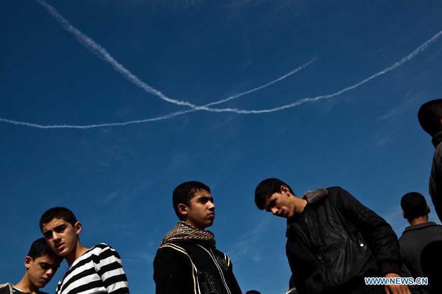 Vapor trails from Israeli F16 fighter jets are seen during a funeral in Gaza City, Nov. 20, 2012. Hamas-run Ministry of Health said the death toll since Wednesday in the Gaza Strip has climbed to 130 and more than 1,000 people were wounded in the ongoing Israeli aerial operation on the coastal enclave. (Xinhua/Chen Xu) 