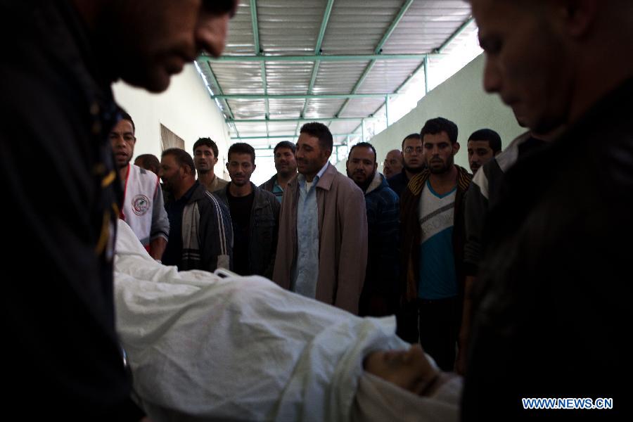 Palestinians watch the body of a Palestinian man killed in an Israeli air strike, at Al-Adwan Hospital in Gaza City, Nov. 20, 2012. Hamas-run Ministry of Health said the death toll since Wednesday in the Gaza Strip has climbed to 130 and more than 1,000 people were wounded in the ongoing Israeli aerial operation on the coastal enclave. (Xinhua/Chen Xu) 