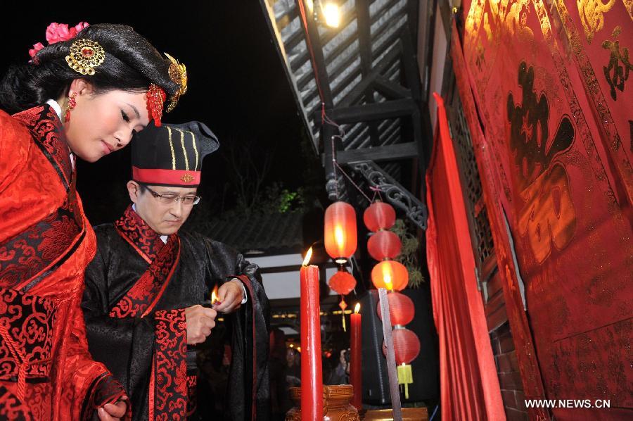 Peng Yong (R) and his bride Chen Yuanyuan (L) attend a ceremony to pay tribute to the heaven, the earth, the ancestors and Confucius during a traditional Chinese wedding in Guiyang, capital of southwest China's Guizhou Province, Nov. 19, 2012. The traditional Chinese wedding, pursuant to the etiquettes of the Zhou Dynasties (1046-256BC), sees a resurgence in recent years as the sense of identity grows among modern Chinese couples. (Xinhua/Ou Dongqu) 